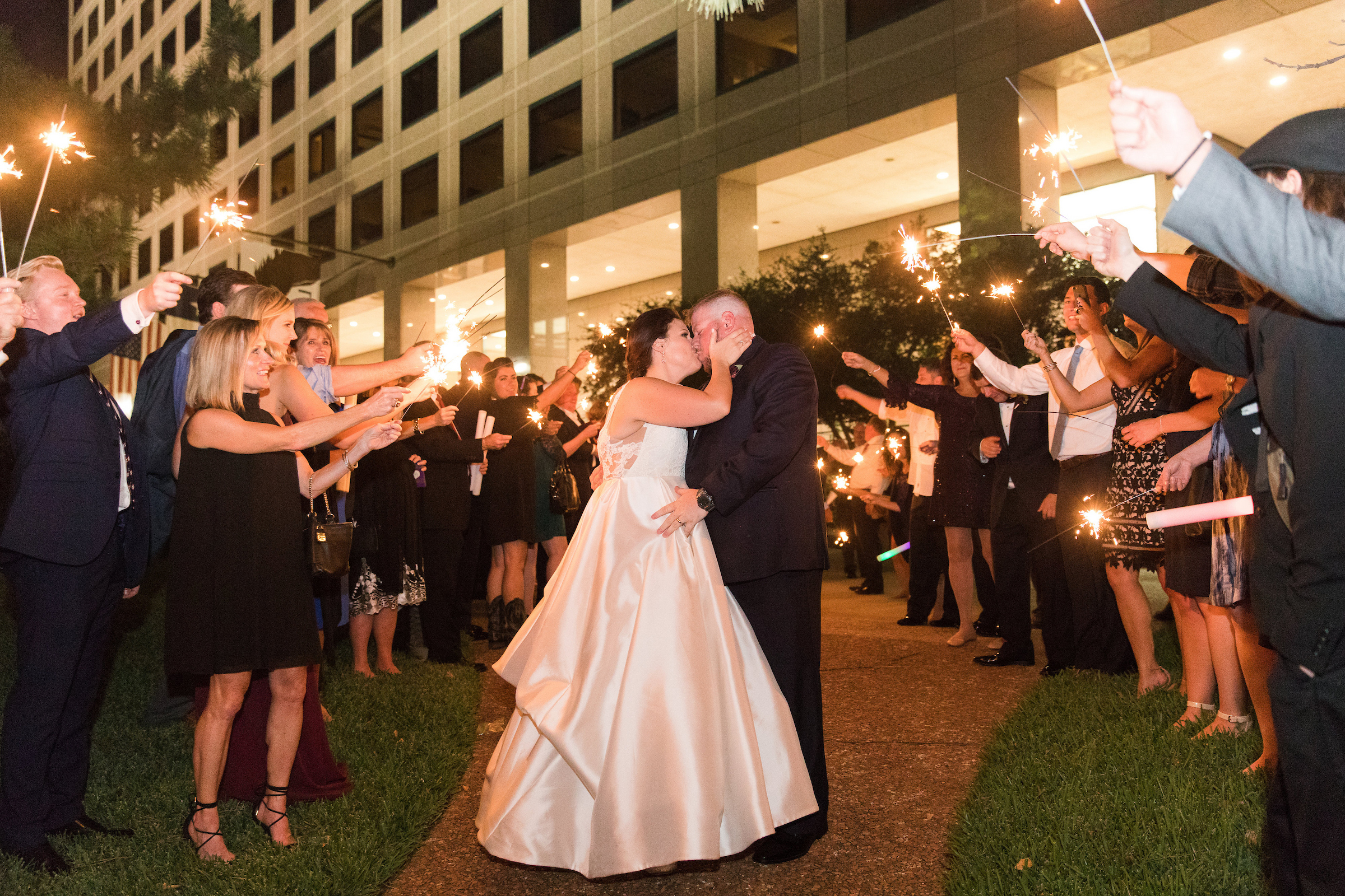 Bride & Groom stopping for a kiss while leaving their reception