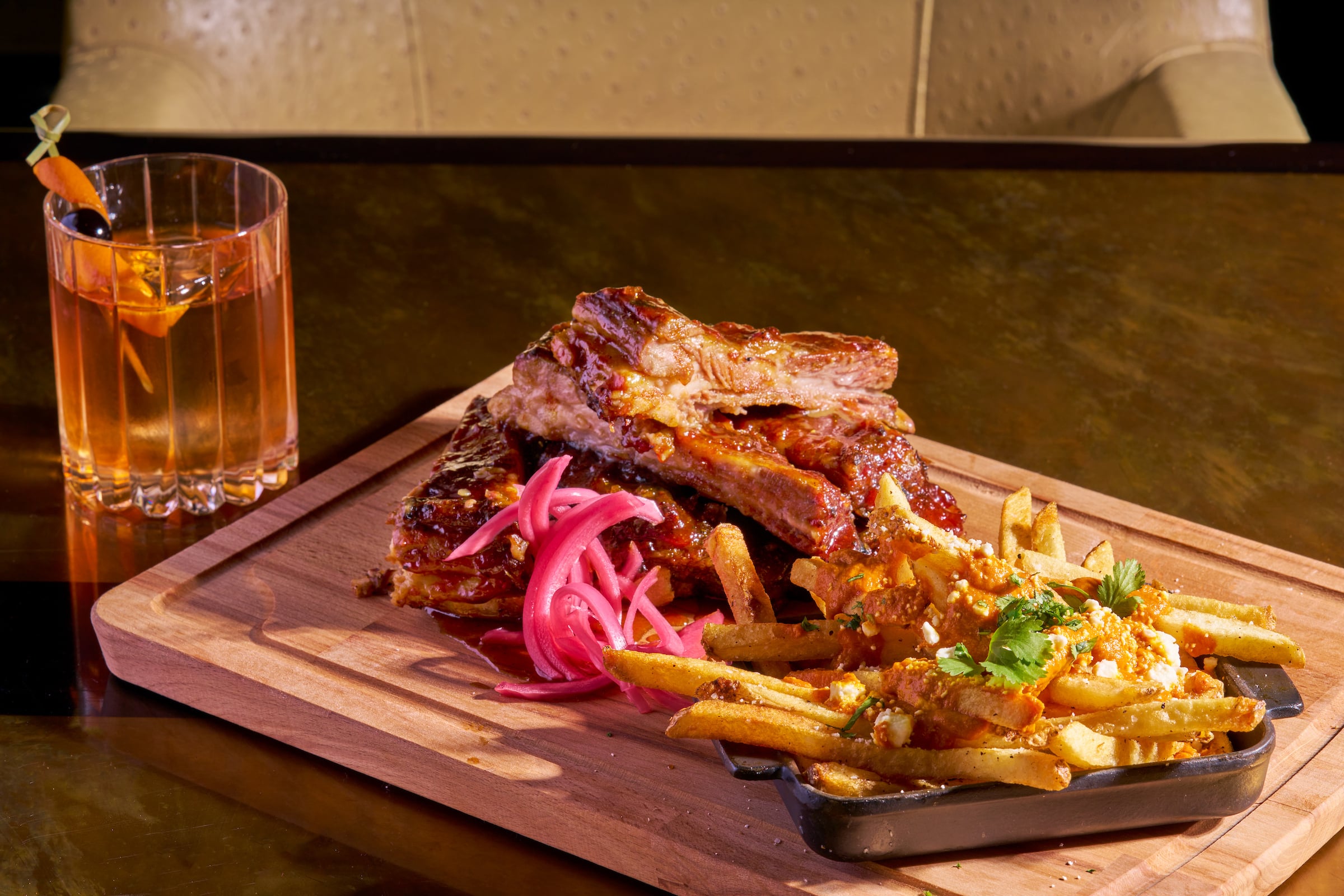 Wooden platter of food & cocktail drink