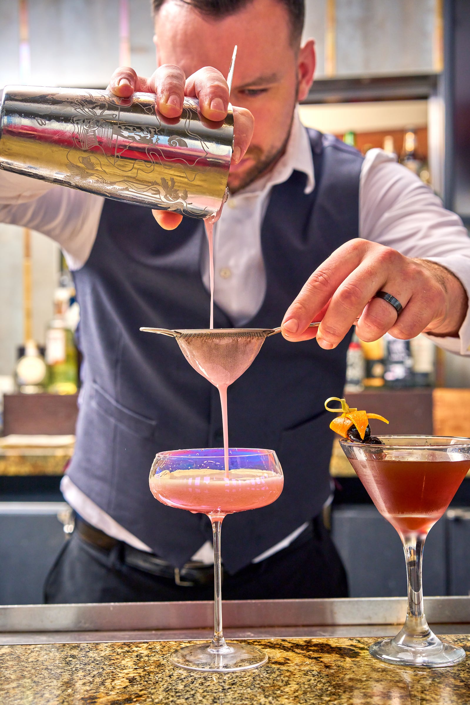Bartender pouring cocktail into a glass