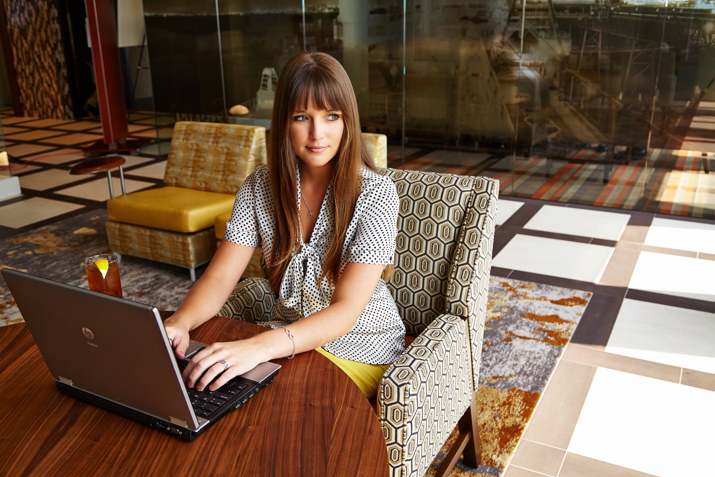 Woman seated with her computer & a glass of tea