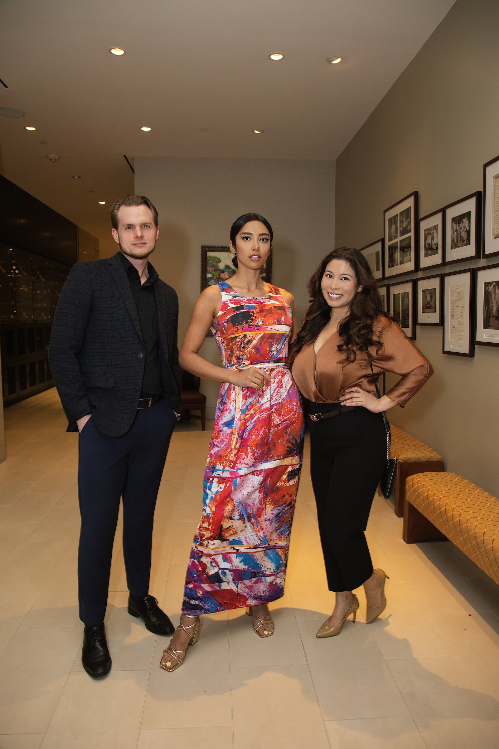 Two women & a man posing at a private event