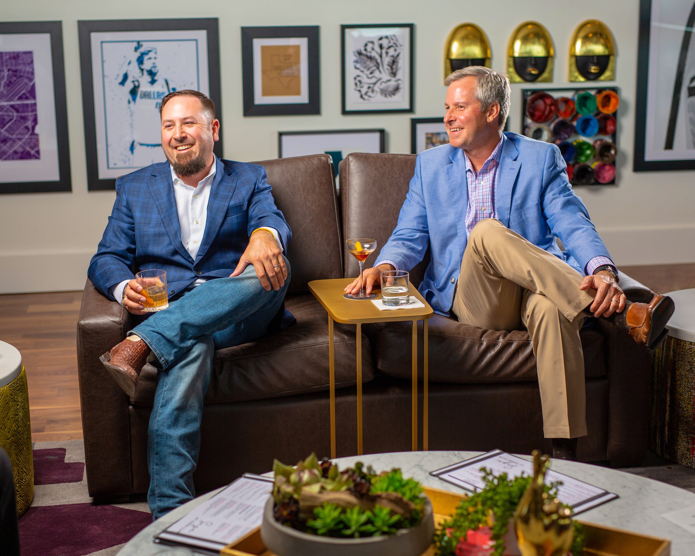 Two men sitting in chairs with drinks