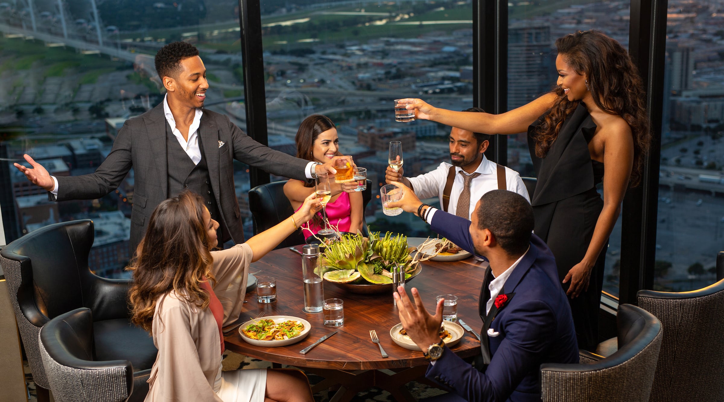 Group of 6 diners celebrating & toasting