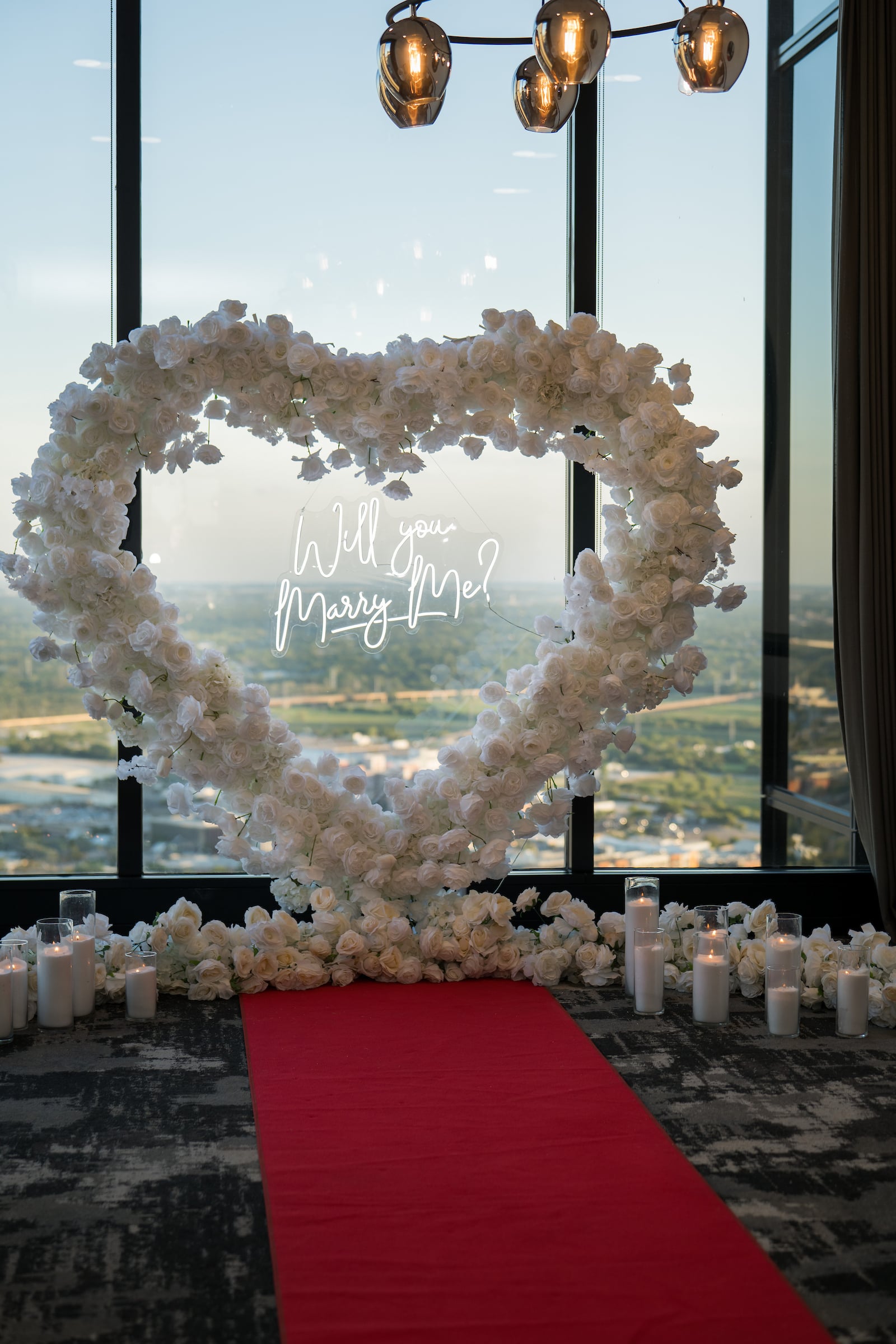 Large decorative heart of white flowers with a sign 'Will you marry me?'