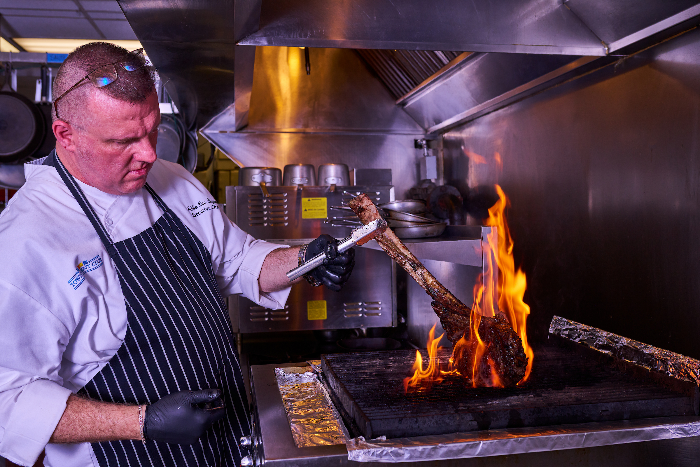 Chef cooking a steak on a kitchen grill