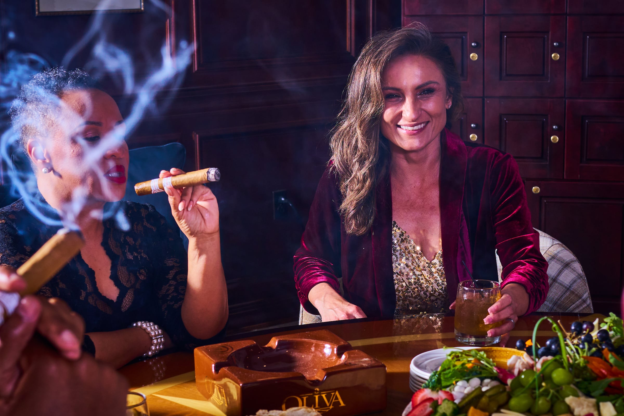 Two women at a private cigar event with drinks on table