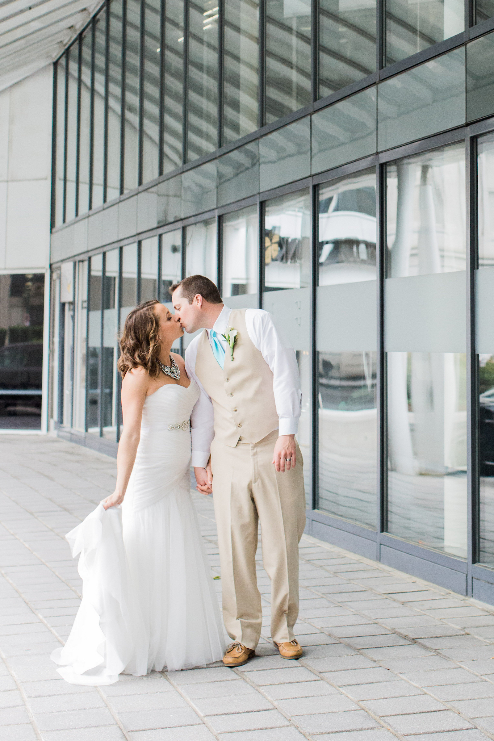 Bride & Groom kissing in front of windows