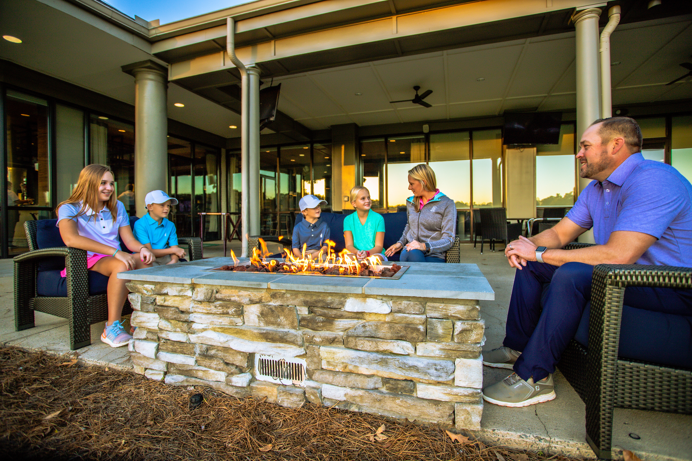 Family hanging out by a fire pit
