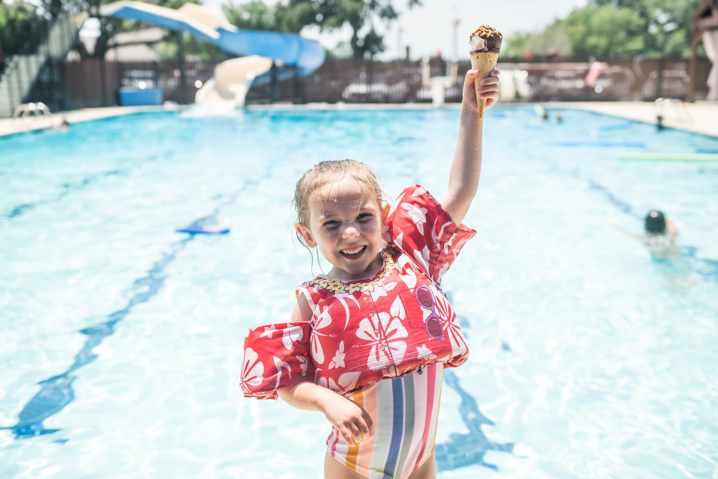 Young Girl in Pool with Ice Cream Cone