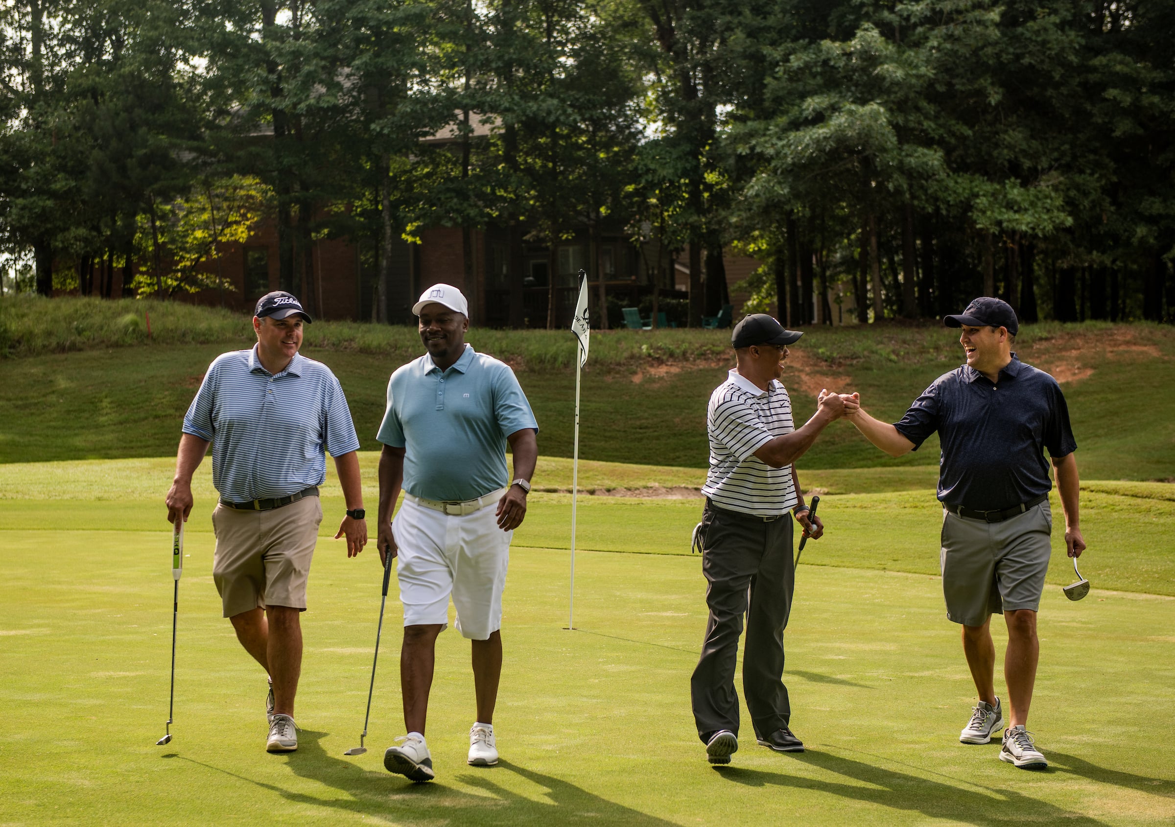 4 male golfers walking on a golf course